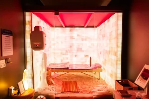Private salt room with Himalayan salt walls, red light therapy pads, and a serene, spa-like atmosphere.
